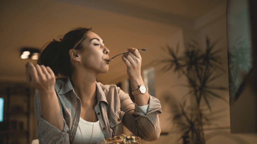 Mulher comendo e considerando como a alimentação impacta seu sono