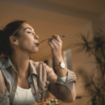 Mulher comendo e considerando como a alimentação impacta seu sono